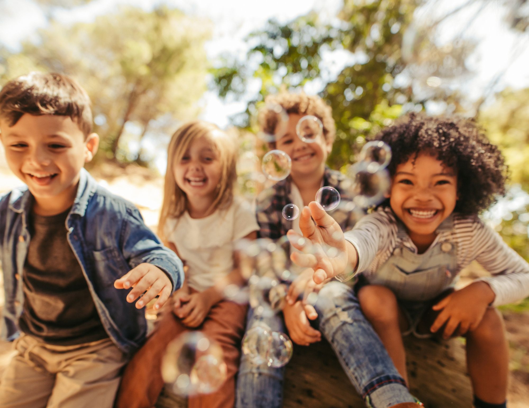 Children playing joyfully with bubbles outdoors